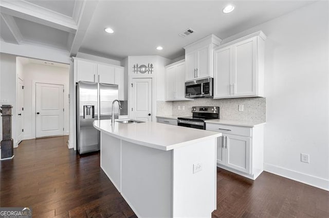 kitchen featuring a center island with sink, stainless steel appliances, light countertops, white cabinetry, and a sink