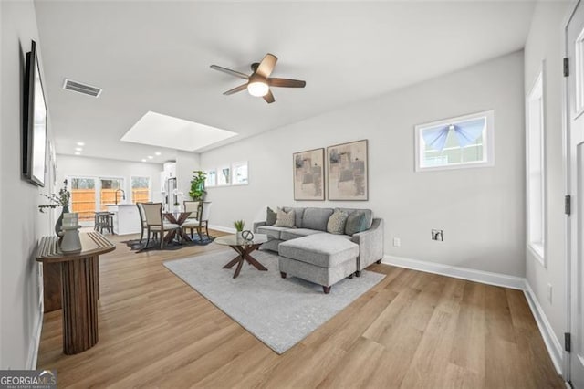 395 Lake Ave, Atlanta, GA 30318 - living area with light wood-type flooring, baseboards, visible vents, a skylight, and ceiling fan