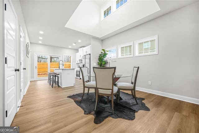 395 Lake Ave, Atlanta, GA 30318 - dining area featuring light wood-type flooring, baseboards, a wealth of natural light, and recessed lighting