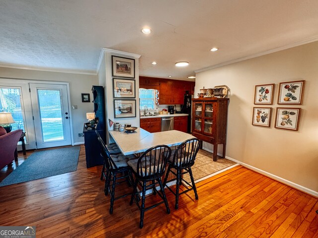 dining room featuring ornamental molding, light wood-type flooring, and baseboards