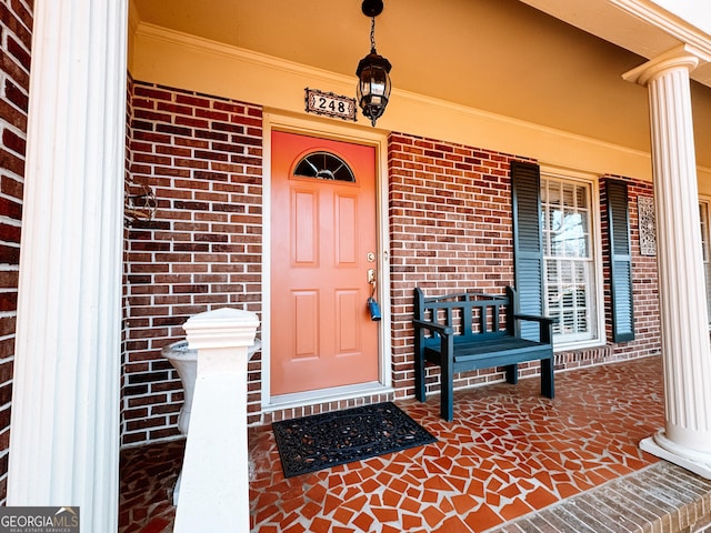 property entrance featuring brick siding and a porch