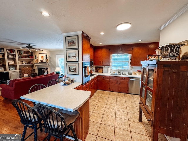 kitchen featuring oven, light countertops, dishwasher, and a peninsula