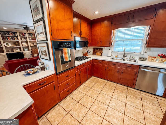 kitchen featuring light tile patterned floors, tasteful backsplash, ceiling fan, appliances with stainless steel finishes, and a sink