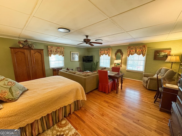 bedroom with a ceiling fan, multiple windows, and light wood finished floors