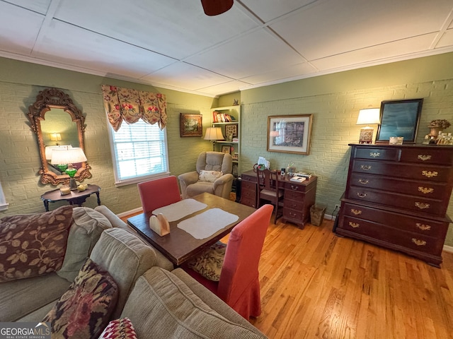 dining room with light wood-style floors and brick wall