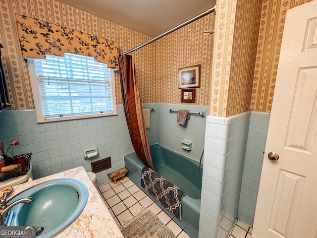 full bath featuring wainscoting, a sink, tile patterned flooring, and wallpapered walls