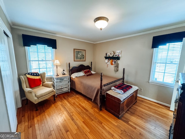 bedroom with light wood-type flooring, baseboards, ornamental molding, and a closet