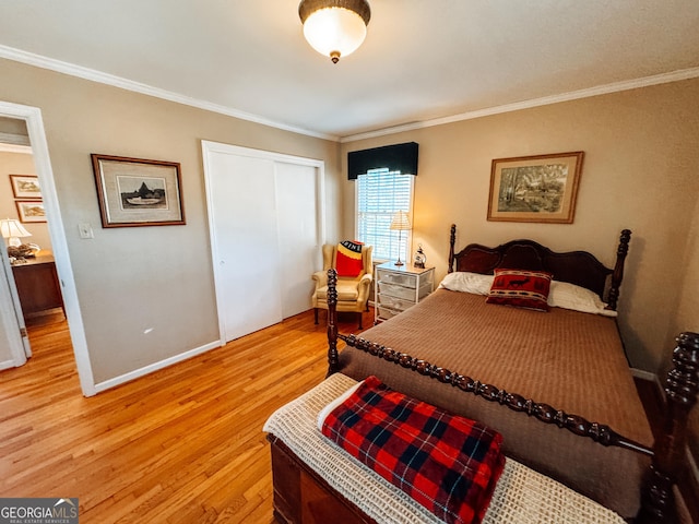 bedroom with light wood-type flooring, a closet, crown molding, and baseboards