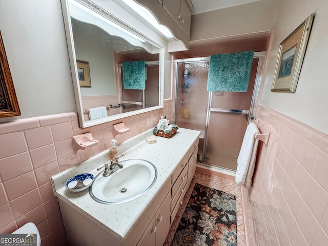 full bathroom featuring a stall shower, tile walls, and vanity