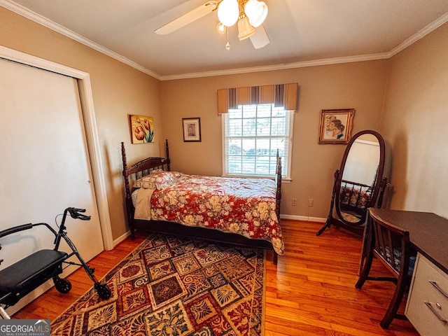 bedroom featuring ornamental molding, light wood-type flooring, ceiling fan, and baseboards