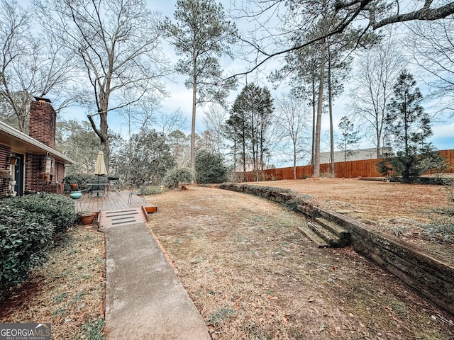 view of yard featuring fence and a wooden deck