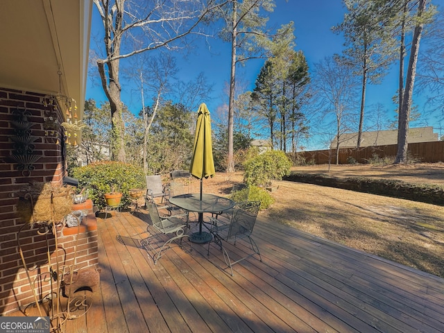 wooden deck with outdoor dining space and fence