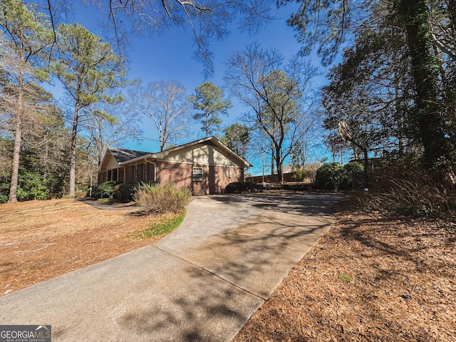 view of front facade featuring driveway and brick siding