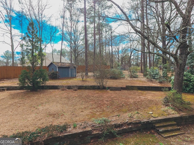 view of yard with an outdoor structure, fence, and a storage unit