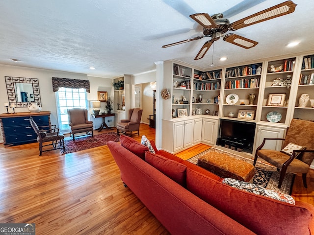 living area featuring a textured ceiling, light wood finished floors, a ceiling fan, and recessed lighting