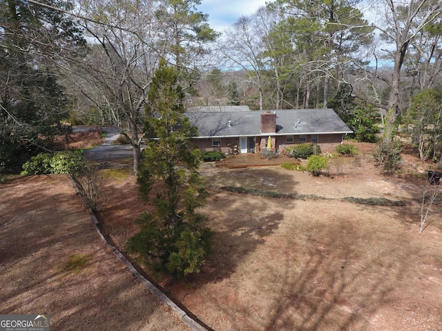 view of front of property featuring driveway and a chimney