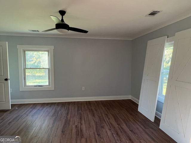 unfurnished bedroom with baseboards, visible vents, dark wood-type flooring, and crown molding