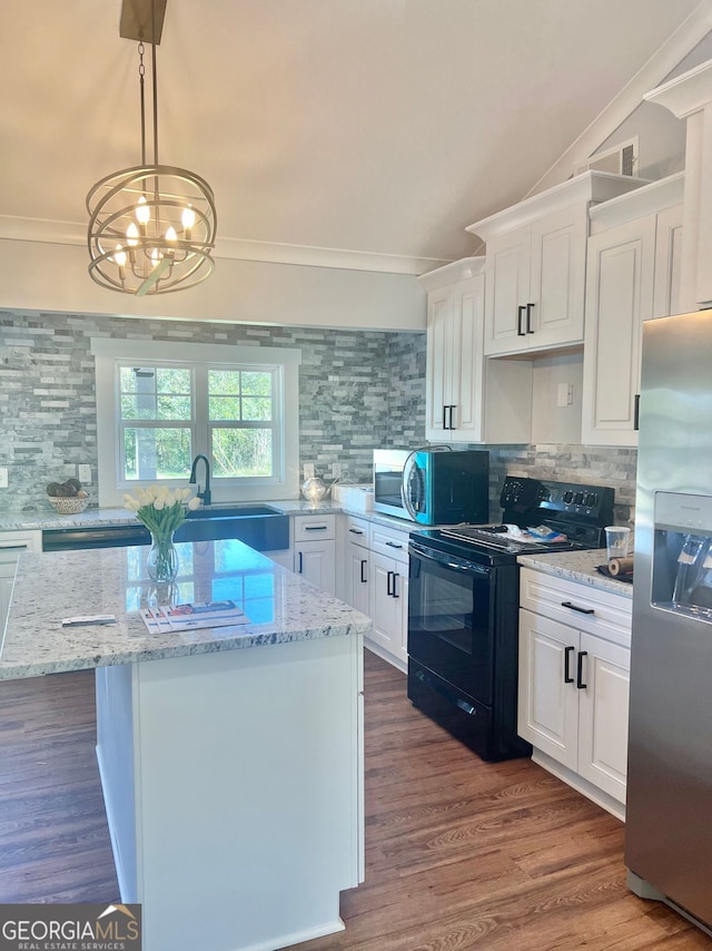 kitchen with hanging light fixtures, appliances with stainless steel finishes, a kitchen island, and white cabinetry