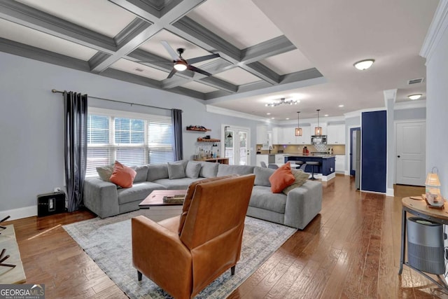 living area featuring dark wood-style flooring, visible vents, coffered ceiling, beamed ceiling, and baseboards