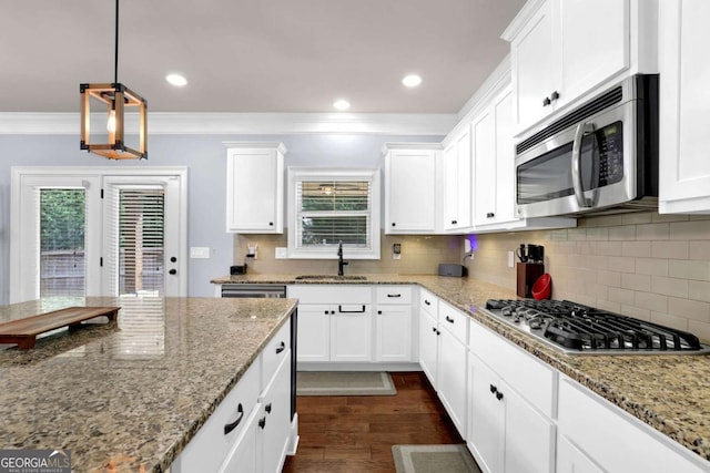 kitchen featuring light stone countertops, appliances with stainless steel finishes, white cabinets, and a sink