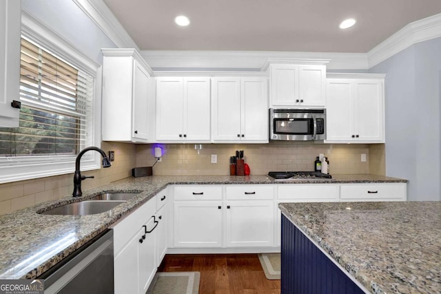 kitchen with white cabinetry, appliances with stainless steel finishes, light stone counters, and a sink