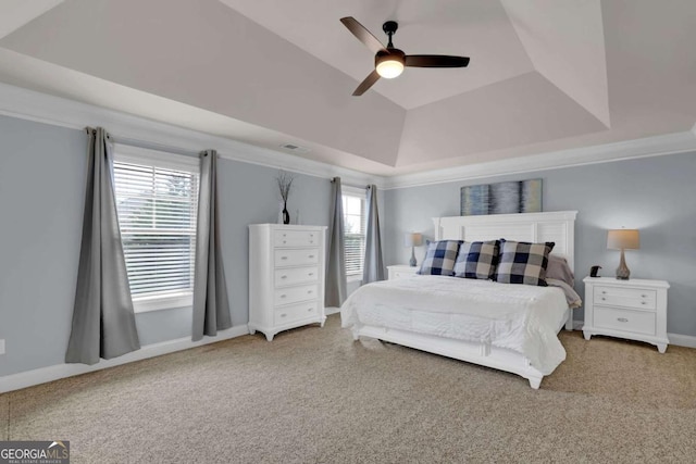 carpeted bedroom featuring a tray ceiling, lofted ceiling, visible vents, a ceiling fan, and baseboards