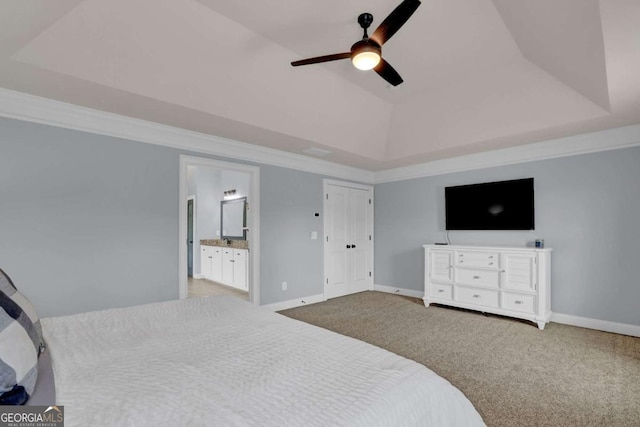 carpeted bedroom with baseboards, a tray ceiling, and crown molding