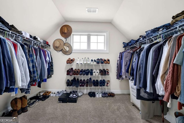 spacious closet with carpet, visible vents, and vaulted ceiling