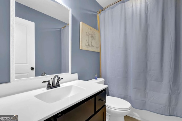 bathroom featuring a shower with shower curtain, vanity, and toilet