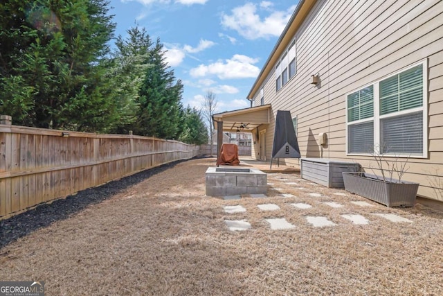 view of yard featuring a fenced backyard and a fire pit