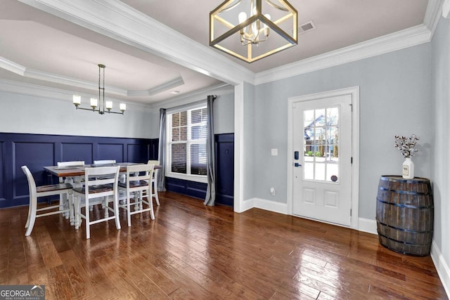 dining space with a chandelier, dark wood-type flooring, visible vents, and crown molding