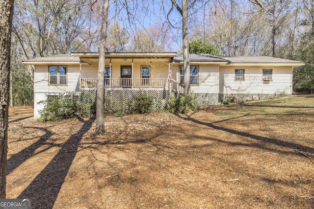 rear view of house with covered porch, metal roof, and a lawn