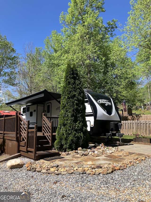 view of front of property featuring fence and a wooden deck