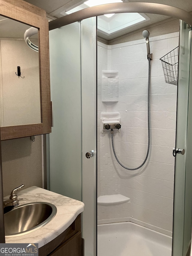 bathroom featuring a shower stall and vanity