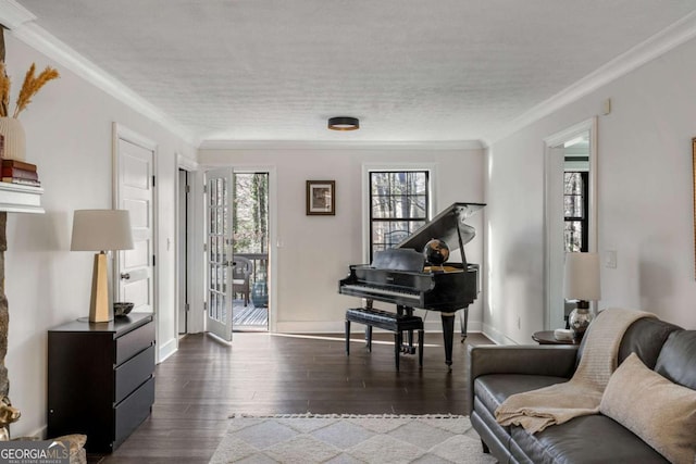 living area featuring plenty of natural light, a textured ceiling, ornamental molding, and wood finished floors