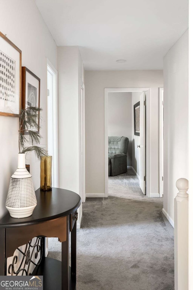 hall featuring carpet and baseboards