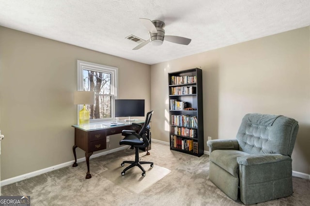 home office with a textured ceiling, carpet, visible vents, and baseboards