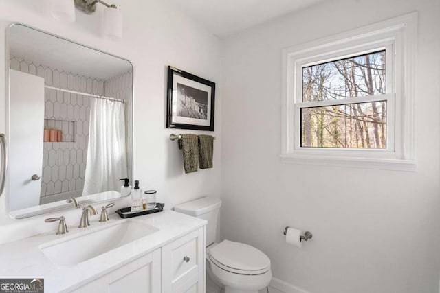 full bath with toilet, curtained shower, baseboards, and vanity