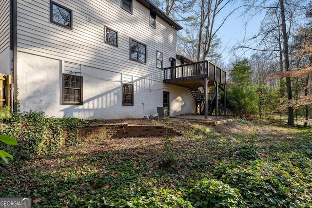 view of side of home with a deck, stairway, and central AC unit