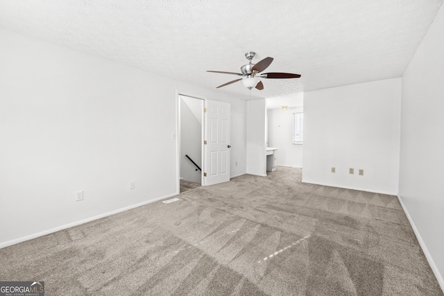 unfurnished bedroom featuring carpet, baseboards, a textured ceiling, and ensuite bathroom