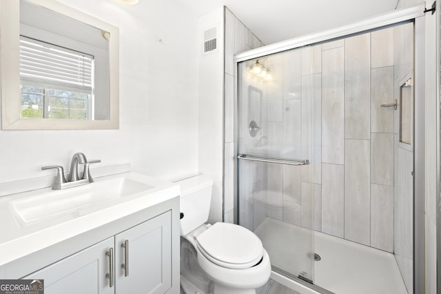 full bath featuring visible vents, vanity, toilet, and a shower stall