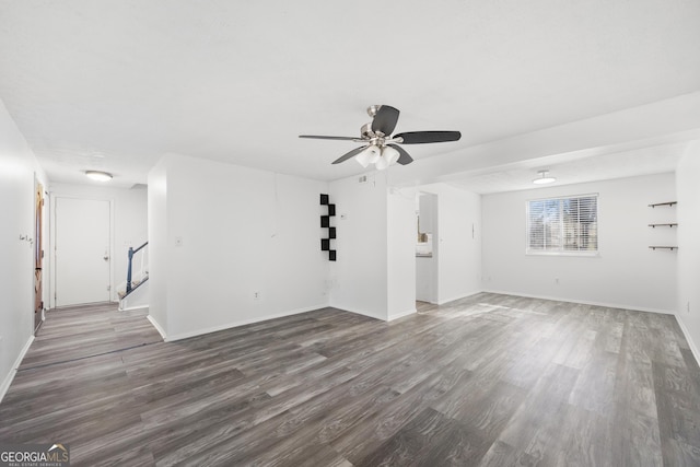 empty room featuring stairs, ceiling fan, wood finished floors, and baseboards