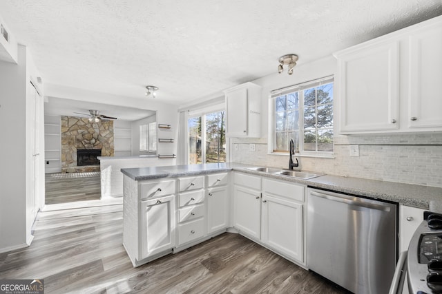 kitchen with a sink, white cabinets, open floor plan, and dishwasher