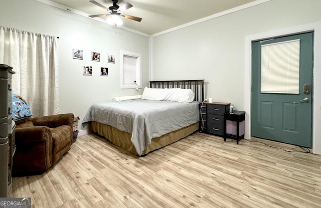 bedroom with ornamental molding, light wood-style flooring, and a ceiling fan