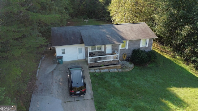 ranch-style home with covered porch, brick siding, and a front yard