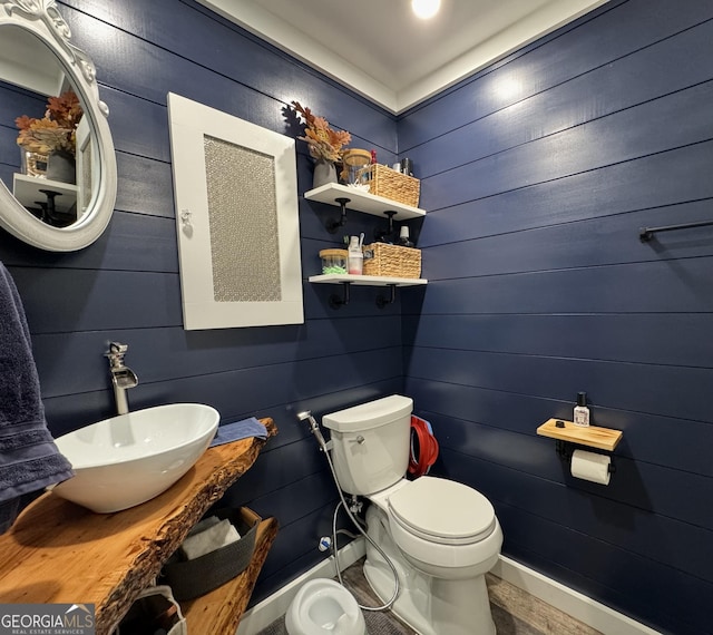 bathroom with toilet, baseboards, and a sink