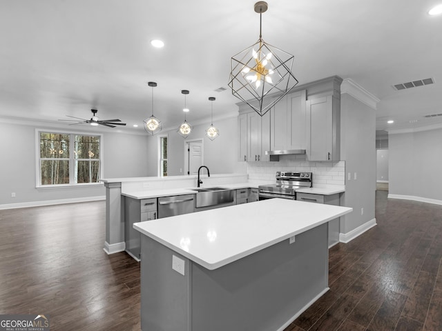 kitchen with visible vents, appliances with stainless steel finishes, light countertops, pendant lighting, and a sink