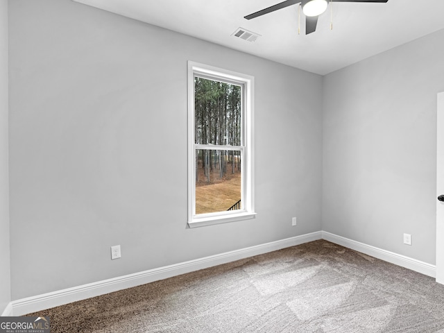 carpeted spare room featuring visible vents, baseboards, and a ceiling fan