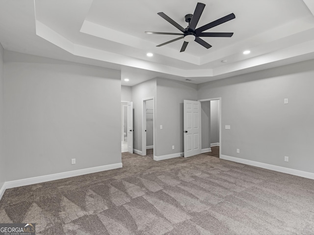 unfurnished bedroom with baseboards, a raised ceiling, and recessed lighting