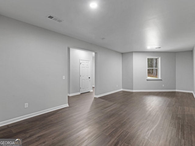 unfurnished room featuring dark wood-style floors, baseboards, and visible vents